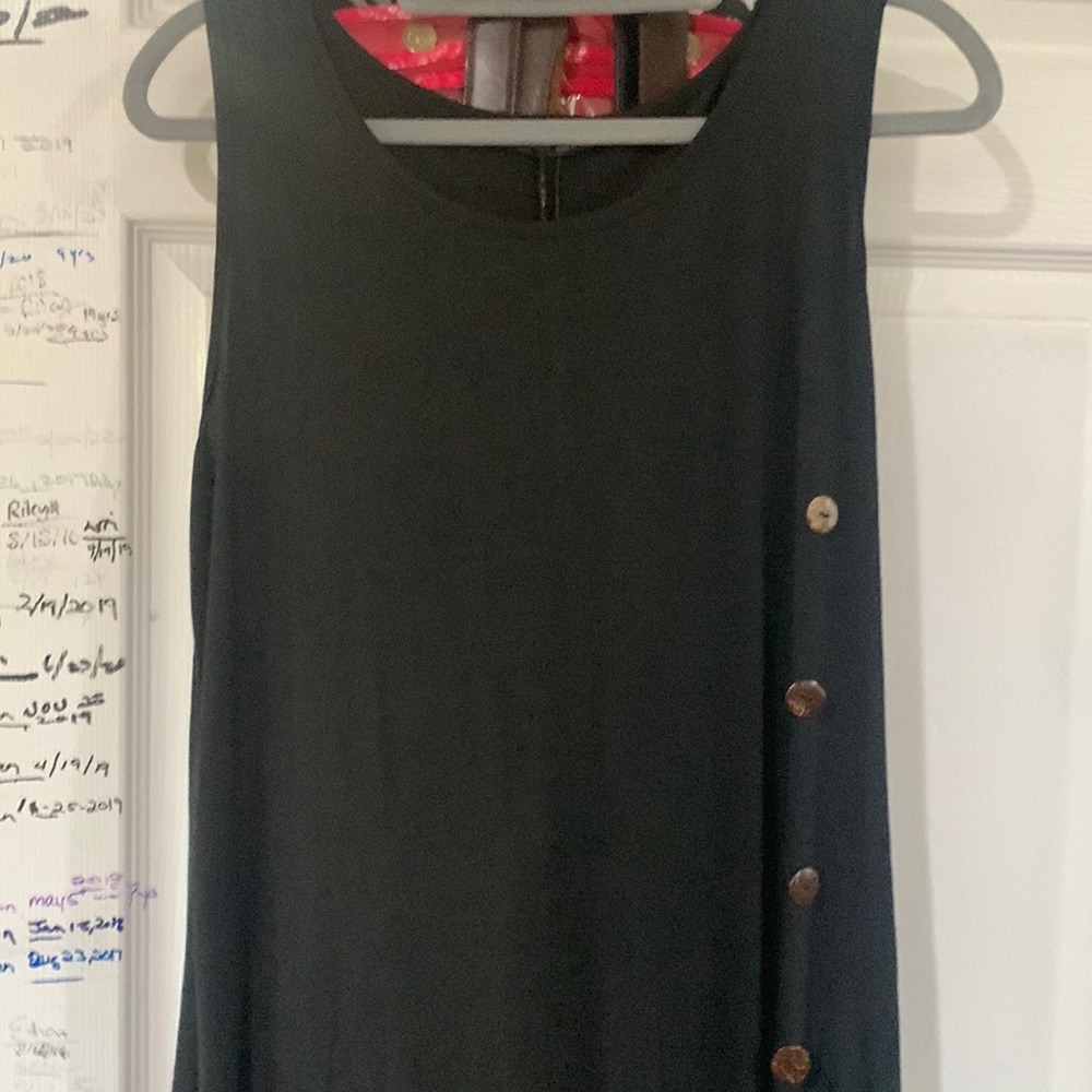 one shoulder strap w/ white buttons on the left by the waist.